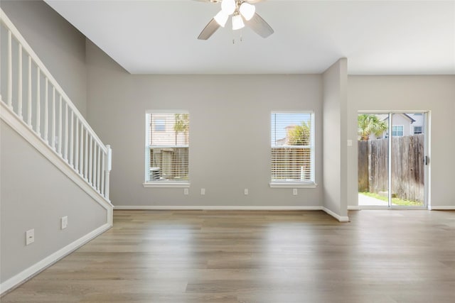 8315 Greys Ln, Houston, TX 77095 - unfurnished living room with healthy amount of natural light, stairs, a ceiling fan, and wood finished floors