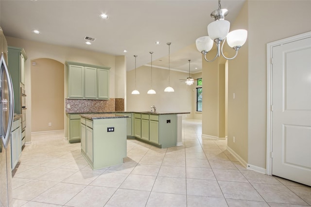 20702 Elderwood Terrace Dr, Richmond, TX 77406 - kitchen featuring green cabinetry, a center island, arched walkways, a ceiling fan, and backsplash