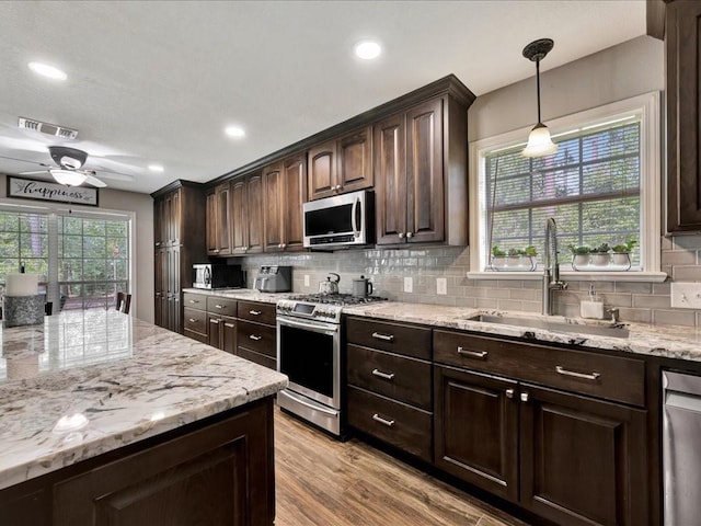 238 Royal Pnes, Lufkin, TX 75904 - kitchen with stainless steel appliances, a sink, tasteful backsplash, dark brown cabinetry, and recessed lighting
