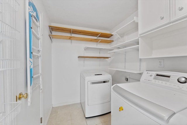11104 Quinlan N Lake Dr, Conroe, TX 77303 - laundry area featuring cabinet space, washing machine and dryer, and light tile patterned floors