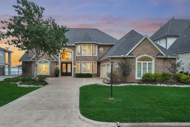 131 Sarasota Cir S, Montgomery, TX 77356 - french provincial home with french doors, concrete driveway, brick siding, and a yard