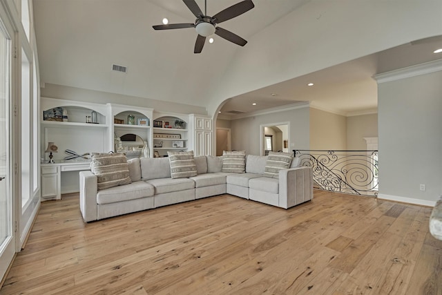131 Sarasota Cir S, Montgomery, TX 77356 - living area featuring ceiling fan, light wood-style flooring, crown molding, high vaulted ceiling, and arched walkways