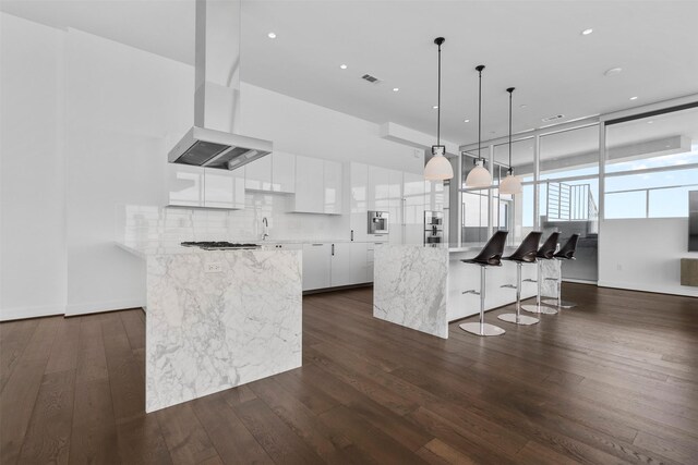 4521 San Felipe St Unit 3101, Houston, TX 77027 - kitchen with island exhaust hood, modern cabinets, white cabinetry, a kitchen breakfast bar, and dark wood-type flooring