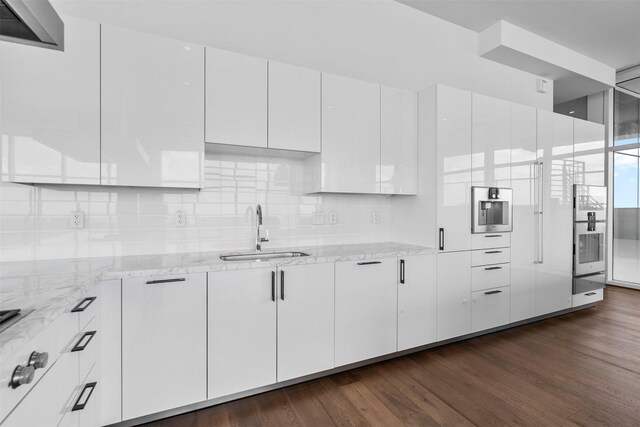 4521 San Felipe St Unit 3101, Houston, TX 77027 - kitchen featuring white cabinets, dark wood-style floors, light stone countertops, and decorative backsplash