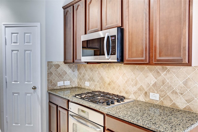 24430 Silverton Valley Ln, Katy, TX 77494 - kitchen with appliances with stainless steel finishes, light stone countertops, and decorative backsplash