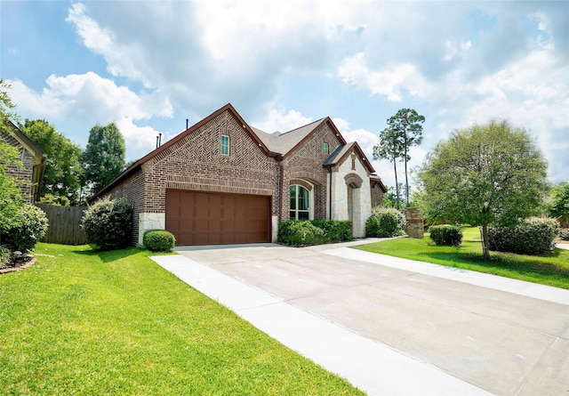 31007 Laurel Creek Ln, Conroe, TX 77385 - french country style house with brick siding, an attached garage, concrete driveway, and stone siding