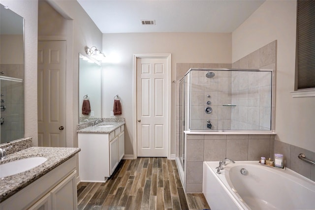 31007 Laurel Creek Ln, Conroe, TX 77385 - bathroom featuring a shower stall, wood finished floors, a bath, and two vanities