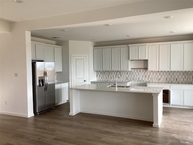 3105 Harrier Dr, Katy, TX 77493 - kitchen with stainless steel fridge, a sink, a center island with sink, dark wood finished floors, and backsplash