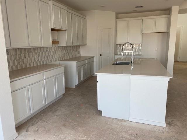 3105 Harrier Dr, Katy, TX 77493 - kitchen featuring a sink, a kitchen island with sink, backsplash, and concrete flooring