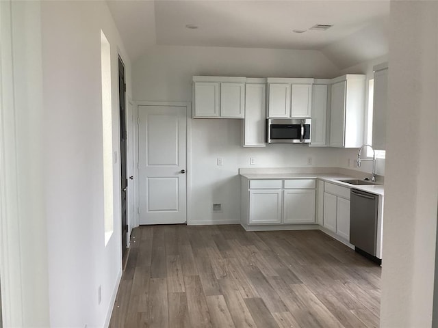 3105 Harrier Dr, Katy, TX 77493 - kitchen featuring a sink, stainless steel appliances, lofted ceiling, light wood-style flooring, and light countertops