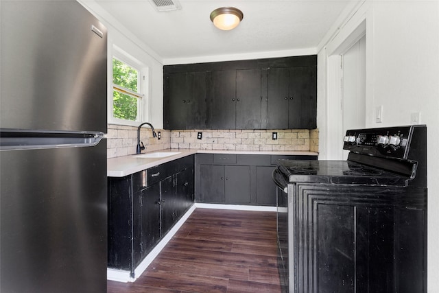 12602 24th St, Santa Fe, TX 77510 - kitchen featuring freestanding refrigerator, black electric range, a sink, dark wood-style floors, and backsplash