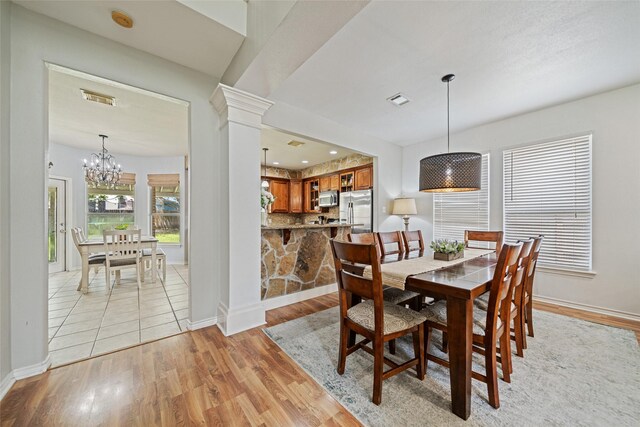 5325 High Bank Dr, Corpus Christi, TX 78413 - dining space featuring light wood-style flooring, baseboards, a chandelier, and ornate columns