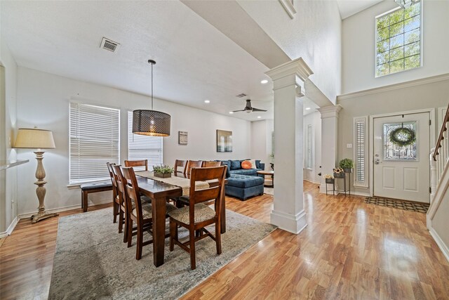 5325 High Bank Dr, Corpus Christi, TX 78413 - dining space featuring decorative columns, plenty of natural light, light wood-style flooring, a ceiling fan, and a towering ceiling