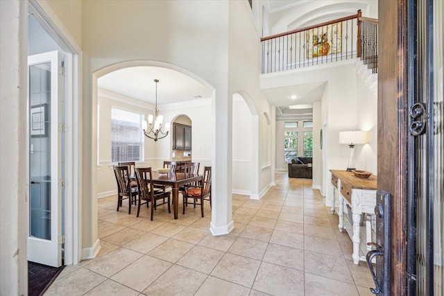 110 Deer Plain Dr, Spring, TX 77389 - entryway with crown molding, arched walkways, light tile patterned floors, a chandelier, and baseboards