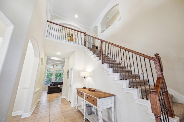110 Deer Plain Dr, Spring, TX 77389 - stairway featuring a high ceiling, tile patterned flooring, arched walkways, baseboards, and recessed lighting