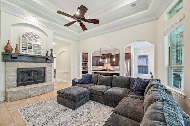 110 Deer Plain Dr, Spring, TX 77389 - living area with ornamental molding, a ceiling fan, a tray ceiling, light tile patterned floors, and a fireplace