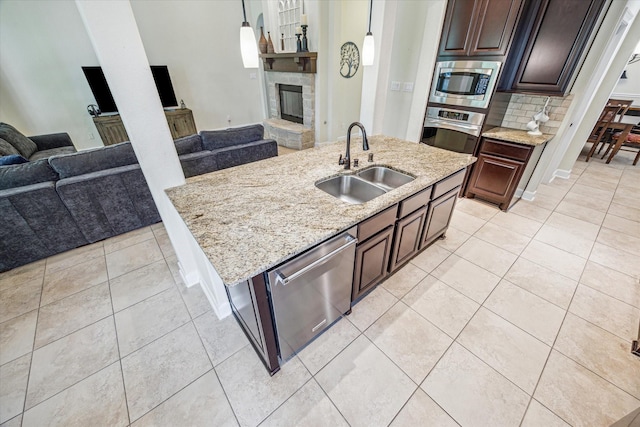 110 Deer Plain Dr, Spring, TX 77389 - kitchen with a sink, appliances with stainless steel finishes, open floor plan, a fireplace, and light tile patterned flooring