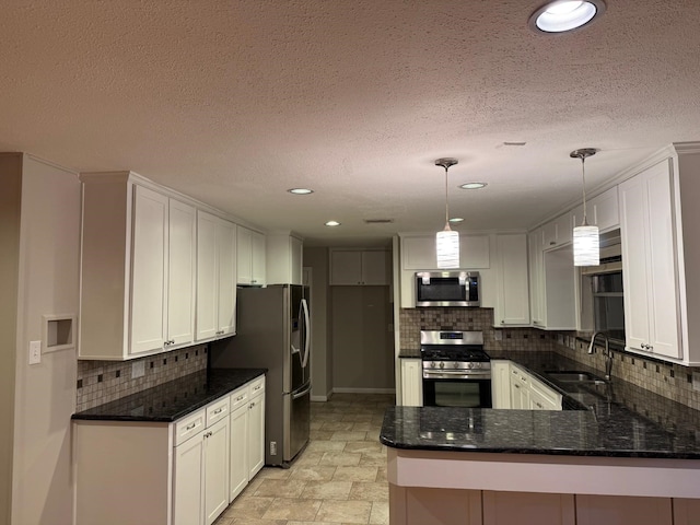 7622 Richmond Ave, Houston, TX 77063 - kitchen with appliances with stainless steel finishes, a sink, decorative backsplash, a peninsula, and white cabinetry