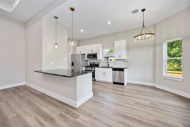 3711 Bain St, Houston, TX 77026 - kitchen with appliances with stainless steel finishes, baseboards, a sink, light wood-style flooring, and plenty of natural light