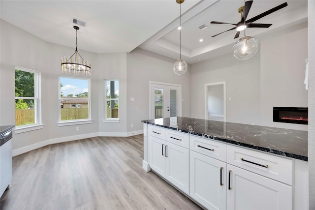 3711 Bain St, Houston, TX 77026 - kitchen featuring light wood-style flooring, white cabinetry, french doors, a raised ceiling, and dark stone countertops