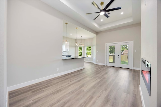 3711 Bain St, Houston, TX 77026 - unfurnished living room with recessed lighting, wood finished floors, ceiling fan, baseboards, and a raised ceiling
