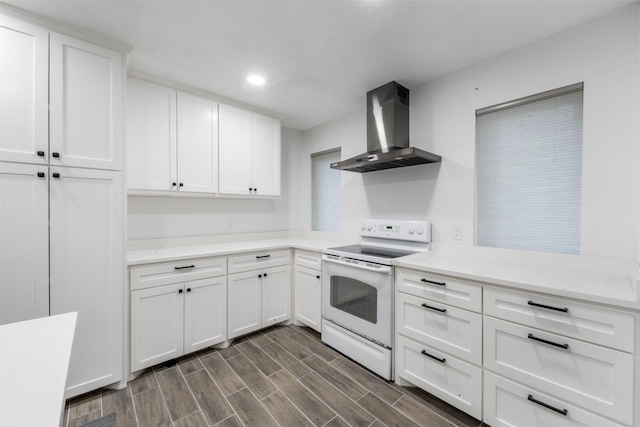 9501 Fondren Rd Unit 9, Houston, TX 77074 - kitchen featuring electric range, wall chimney exhaust hood, white cabinets, light countertops, and dark wood-style flooring