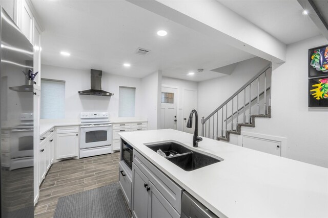 9501 Fondren Rd Unit 9, Houston, TX 77074 - kitchen with white electric stove, wall chimney range hood, a sink, light countertops, and wood tiled floors
