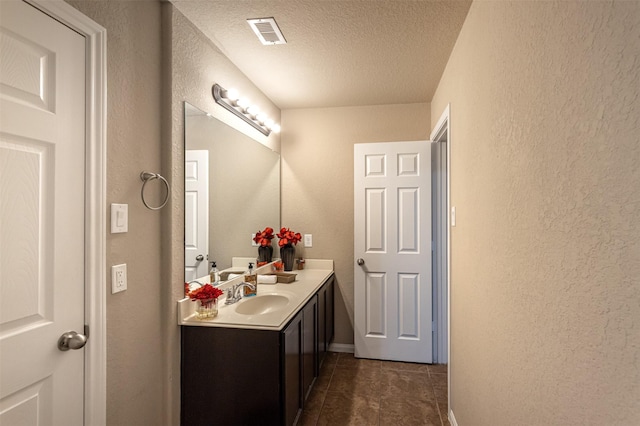 2039 Wembley Way, Rosenberg, TX 77471 - bathroom with a textured ceiling, a textured wall, vanity, tile patterned flooring, and baseboards