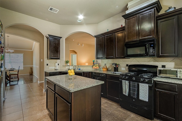 2039 Wembley Way, Rosenberg, TX 77471 - kitchen with black appliances, tasteful backsplash, a kitchen island, tile patterned flooring, and light stone counters