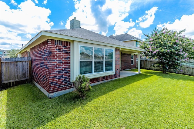 2039 Wembley Way, Rosenberg, TX 77471 - back of house featuring a chimney, brick siding, and a patio area