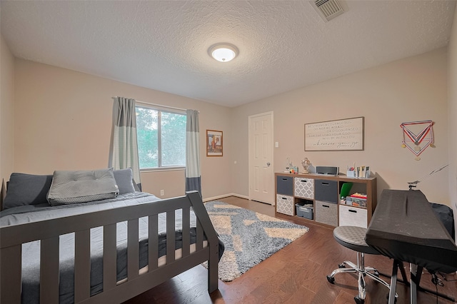 21415 Park Timbers Ln, Katy, TX 77450 - bedroom with wood finished floors, a textured ceiling, and baseboards