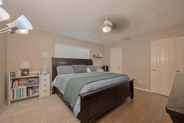 21415 Park Timbers Ln, Katy, TX 77450 - bedroom featuring baseboards, wood finished floors, a ceiling fan, and a textured ceiling