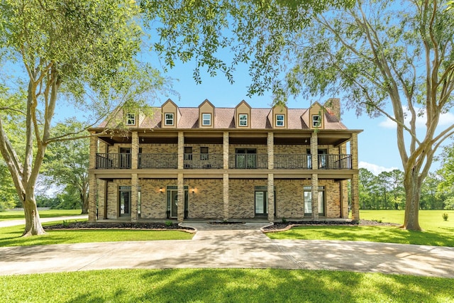 3003 Sky Ranch Dr, Alvin, TX 77511 - view of front of house featuring a balcony, a chimney, a front yard, and brick siding