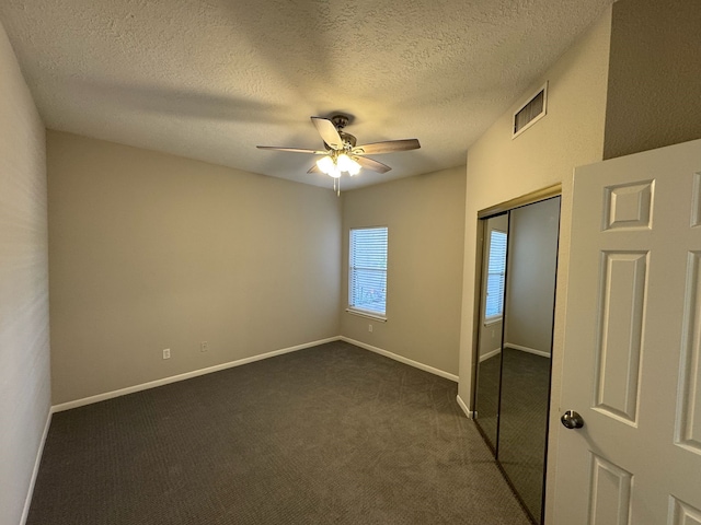 2011 Spenwick Dr Unit 513, Houston, TX 77055 - unfurnished bedroom featuring a closet, dark colored carpet, a textured ceiling, ceiling fan, and baseboards