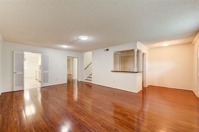 14171 Misty Meadow Ln, Houston, TX 77079 - unfurnished living room with a textured ceiling, stairway, wood finished floors, crown molding, and baseboards
