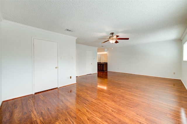 14171 Misty Meadow Ln, Houston, TX 77079 - empty room with ceiling fan, light wood-style floors, a textured ceiling, ornamental molding, and baseboards