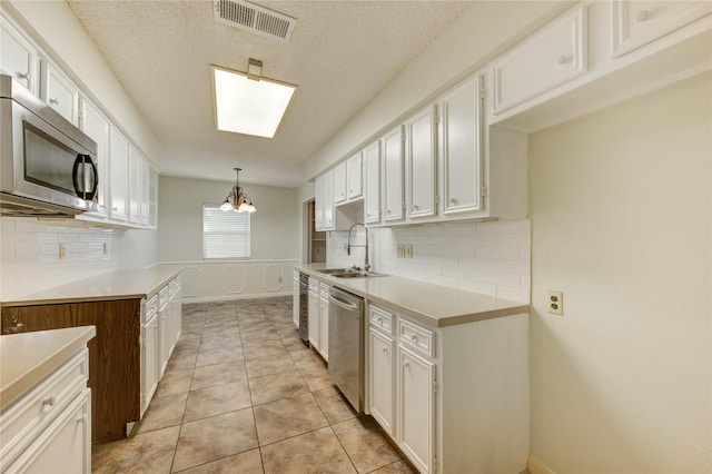14171 Misty Meadow Ln, Houston, TX 77079 - kitchen featuring stainless steel appliances, a sink, white cabinets, tasteful backsplash, and a textured ceiling
