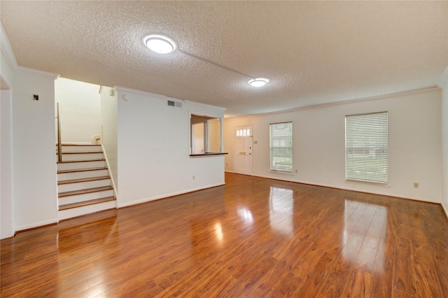 14171 Misty Meadow Ln, Houston, TX 77079 - unfurnished room featuring a textured ceiling, crown molding, wood finished floors, stairway, and baseboards