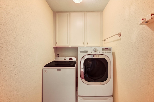 14171 Misty Meadow Ln, Houston, TX 77079 - washroom with cabinet space, washing machine and dryer, and a textured wall