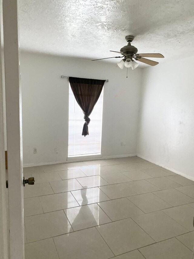 7449 Cook Rd, Houston, TX 77072 - unfurnished room featuring a ceiling fan, a textured ceiling, light tile patterned floors, and baseboards