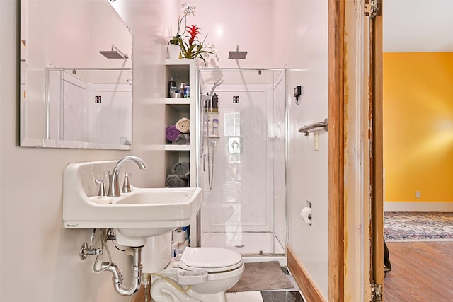 2215 30th St, Galveston, TX 77550 - bathroom featuring toilet, a stall shower, wood finished floors, and baseboards