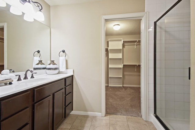 9115 E Lakeside Dr, Magnolia, TX 77354 - bathroom featuring a walk in closet, a shower stall, vanity, and tile patterned flooring