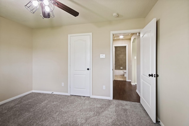 9115 E Lakeside Dr, Magnolia, TX 77354 - unfurnished bedroom with carpet, baseboards, arched walkways, and ceiling fan
