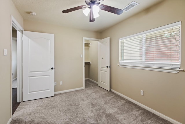 9115 E Lakeside Dr, Magnolia, TX 77354 - unfurnished bedroom featuring carpet flooring, a walk in closet, baseboards, and ceiling fan