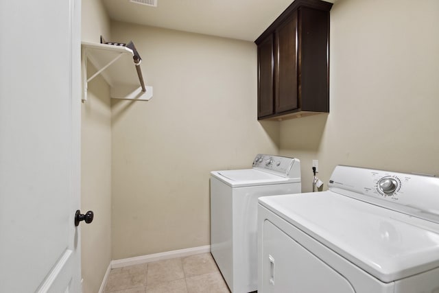 9115 E Lakeside Dr, Magnolia, TX 77354 - washroom featuring washing machine and dryer, cabinet space, baseboards, and light tile patterned flooring