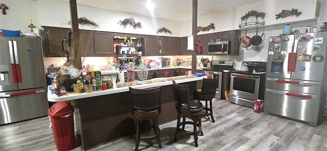1560 Fm 355, Groveton, TX 75845 - kitchen featuring appliances with stainless steel finishes, dark brown cabinets, light wood-style flooring, and light countertops