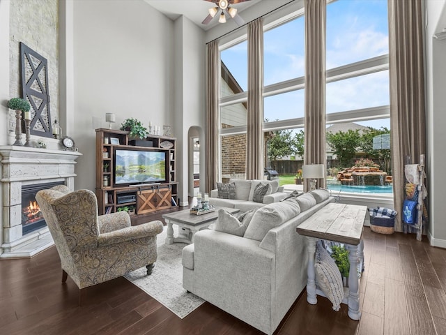 18910 Paddlefish Way, Cypress, TX 77433 - living room featuring dark wood finished floors, a warm lit fireplace, healthy amount of natural light, and a high ceiling