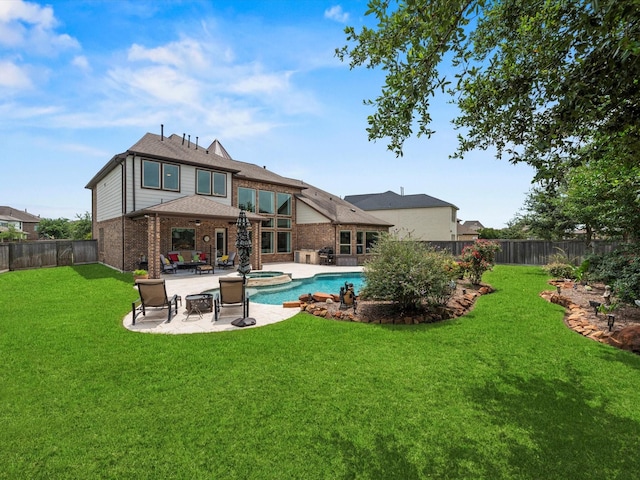 18910 Paddlefish Way, Cypress, TX 77433 - rear view of property featuring brick siding, a fenced backyard, a patio area, and a pool with connected hot tub