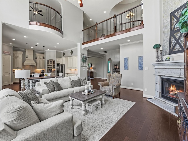 18910 Paddlefish Way, Cypress, TX 77433 - living area with a towering ceiling, a glass covered fireplace, dark wood-type flooring, ceiling fan, and a chandelier