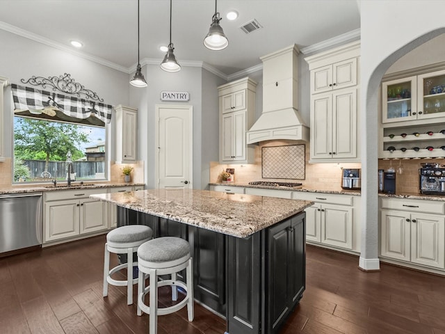 18910 Paddlefish Way, Cypress, TX 77433 - kitchen featuring custom range hood, appliances with stainless steel finishes, a center island, tasteful backsplash, and ornamental molding